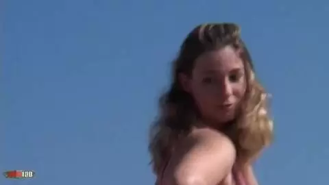 La superbe jeune blonde à gros seins Calia B fait un strip sur la plage  photo 04