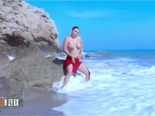 Blonde à gros seins fait un strip sur la plage photo 1