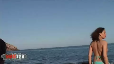 Une belle petite brune fait un strip très chaud en se mouillant dans la mer photo 09